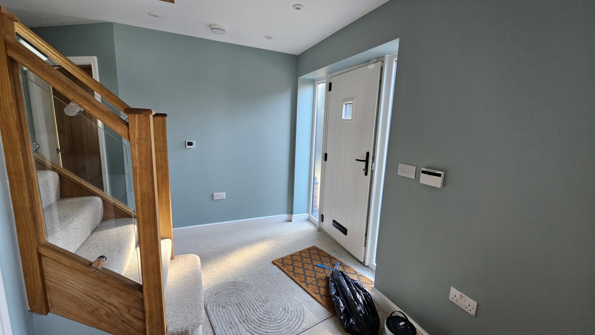 Hallway and oak staircase after, painted blue-grey