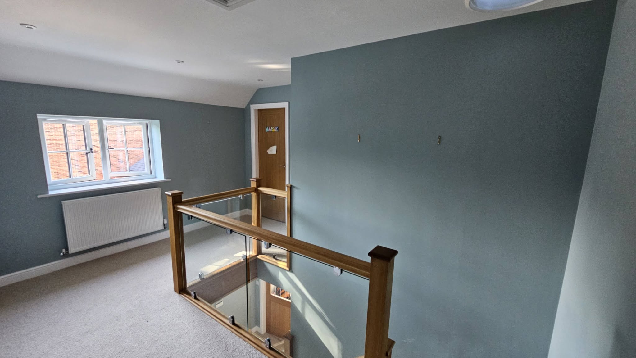 The same landing after, walls painted a soft blue-grey with crisp white skirting