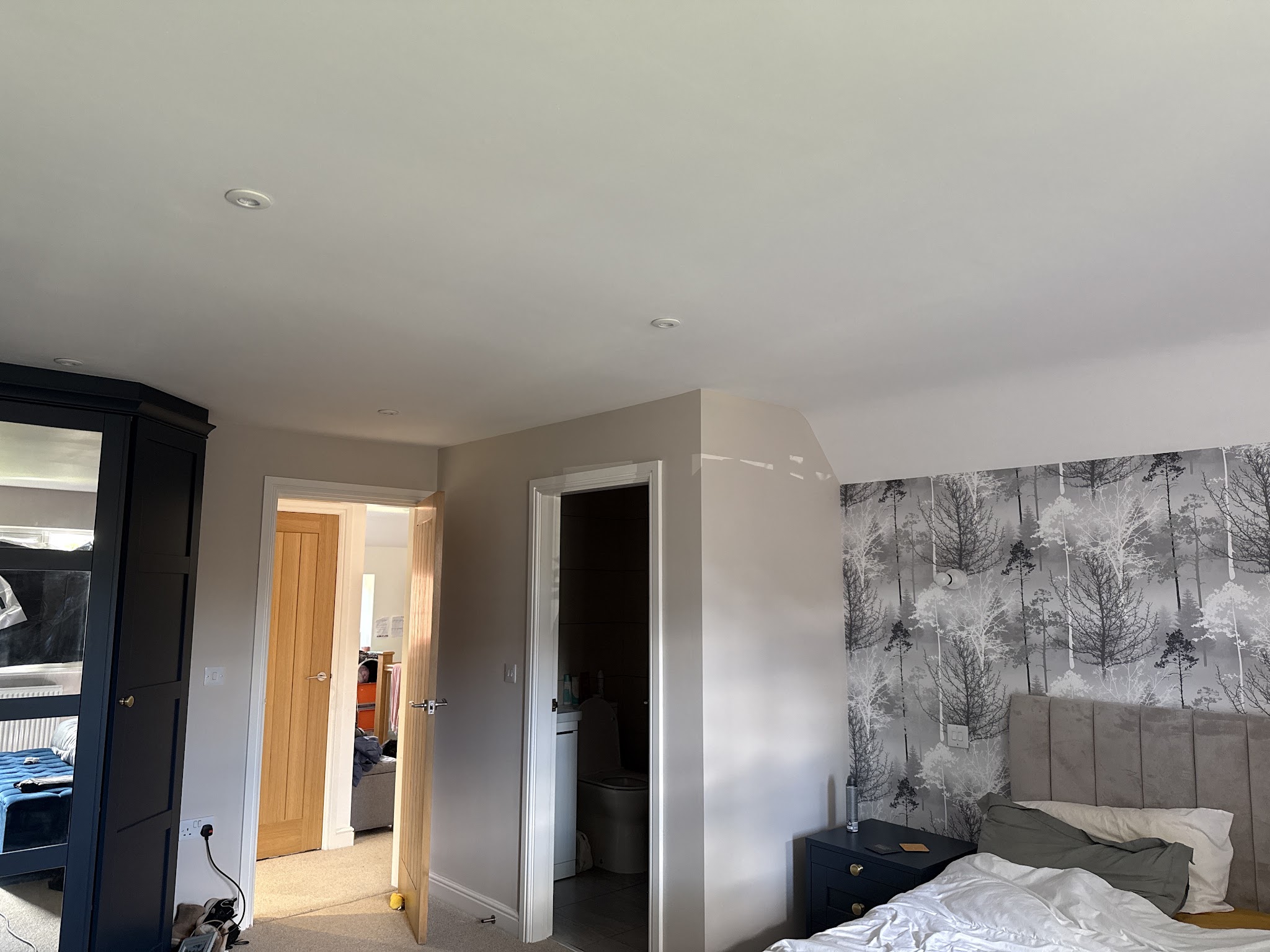 Finished bedroom with a grey botanical wallpaper feature wall